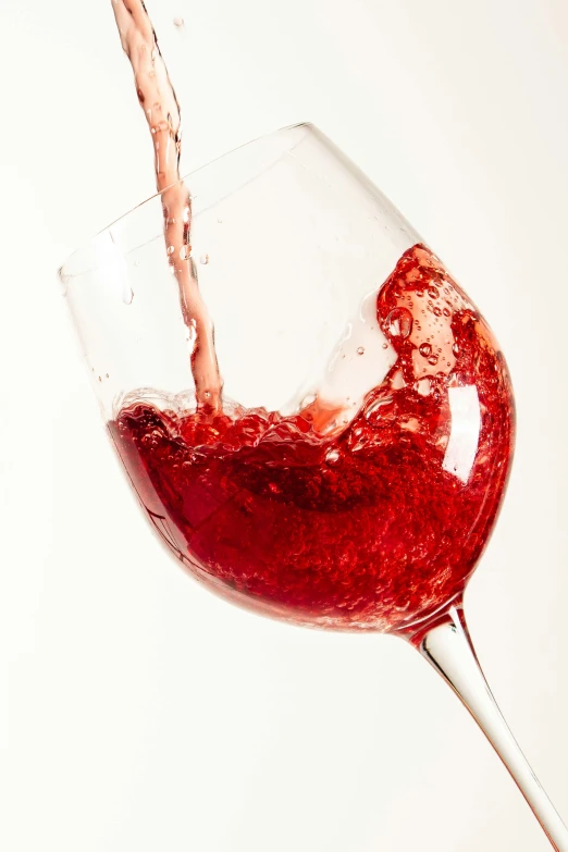 a glass of red wine being poured