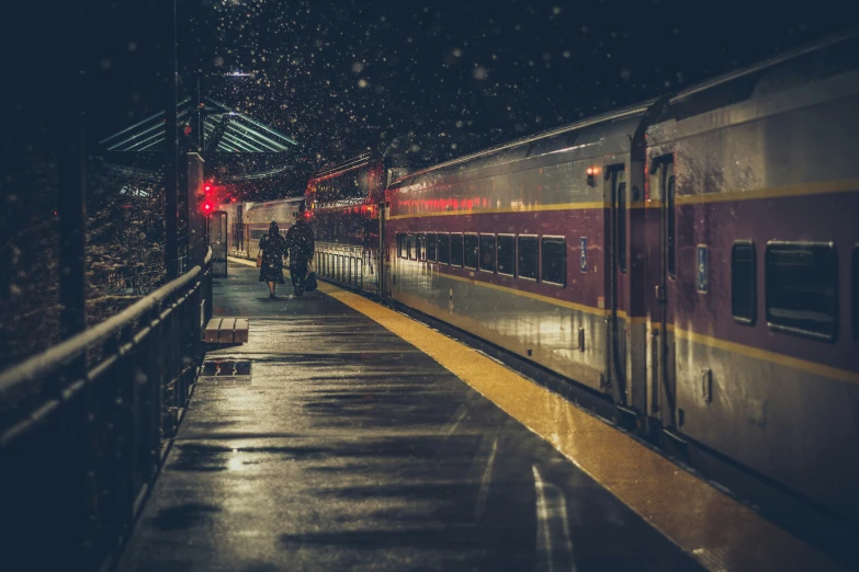 a train stopped at the station and people walk around