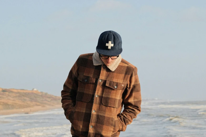 a man in brown standing on top of a beach