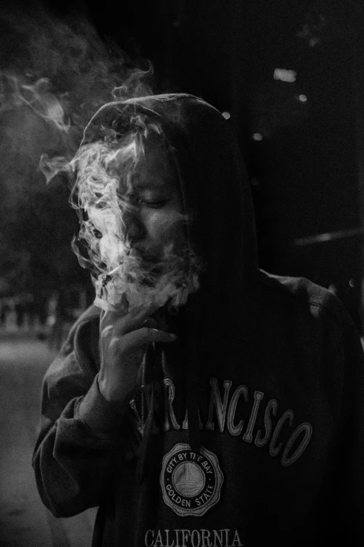 black and white pograph of person smoking a cigarette