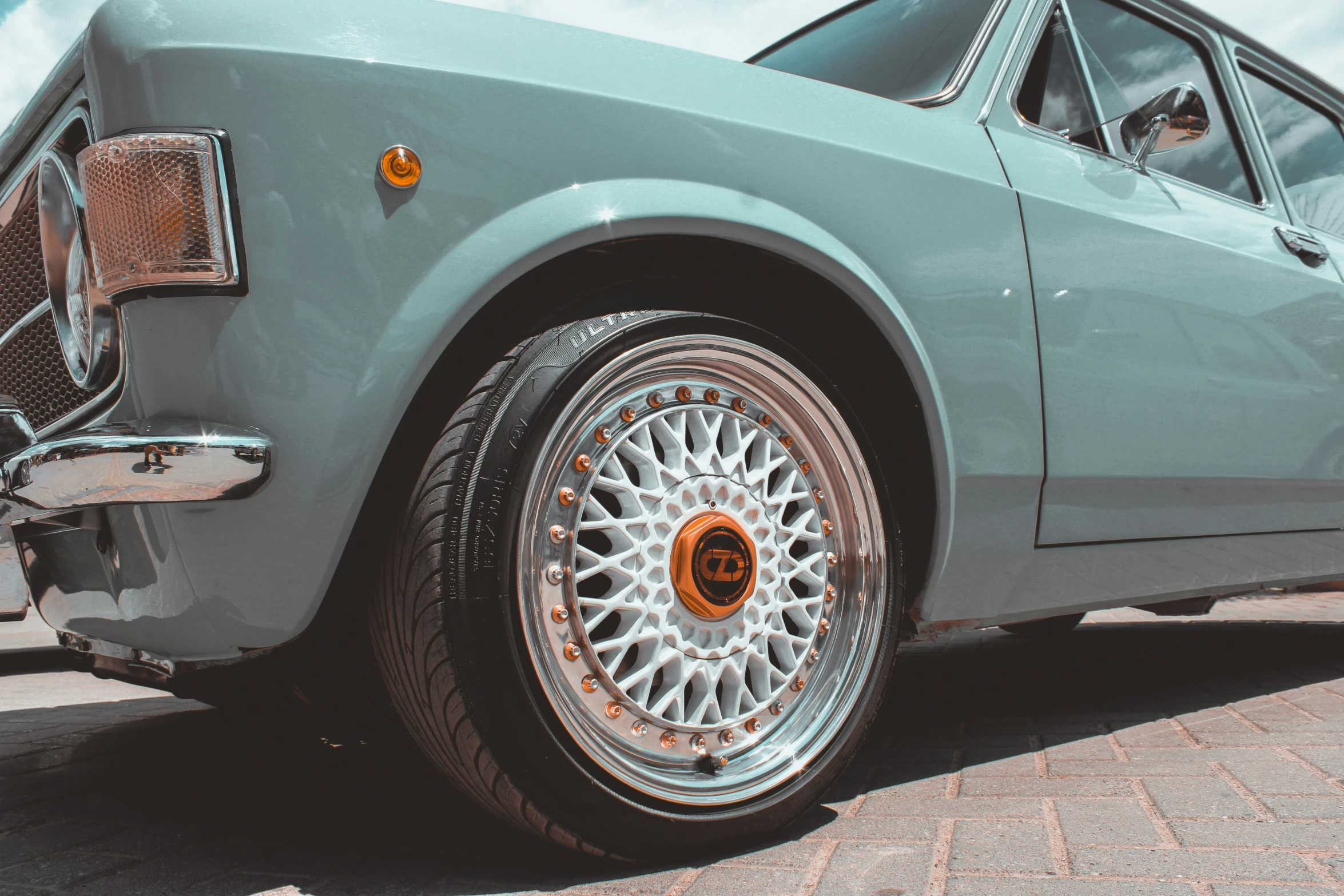 the front wheel and spokes of an old green car