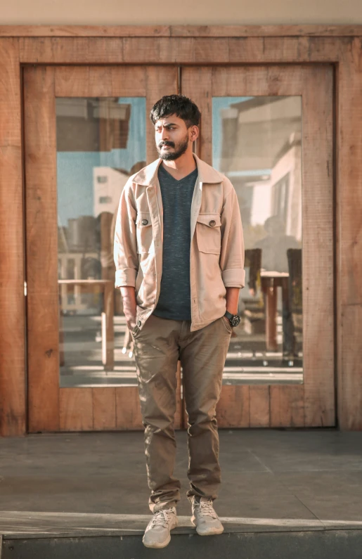 a man standing in front of a door with his legs crossed