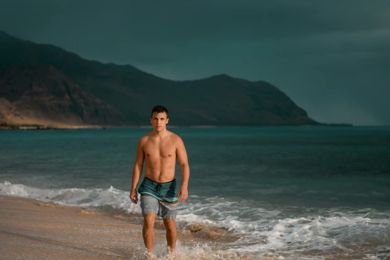 the young man is walking down the beach