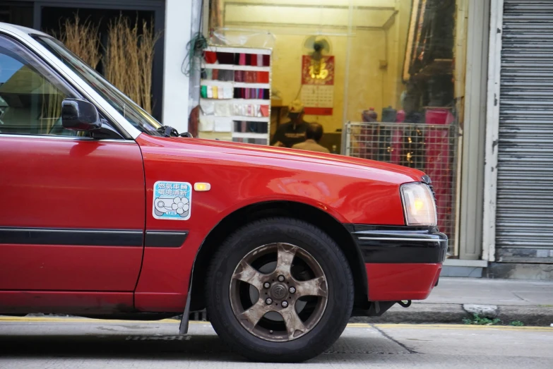 a red car is parked next to a street