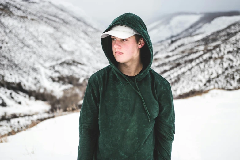 a young person standing in front of snowy mountains