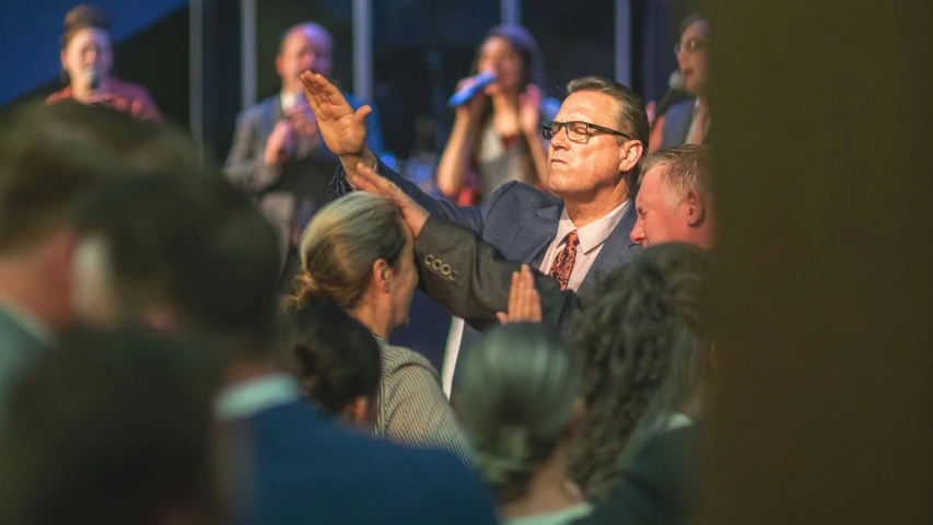 a man in a suit and glasses clapping