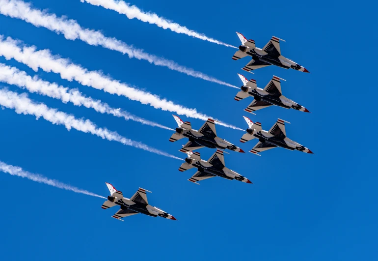 six jets flying in formation while trailing smoke