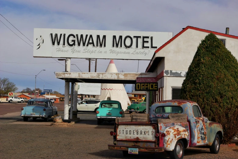 two antique trucks parked in front of a motel