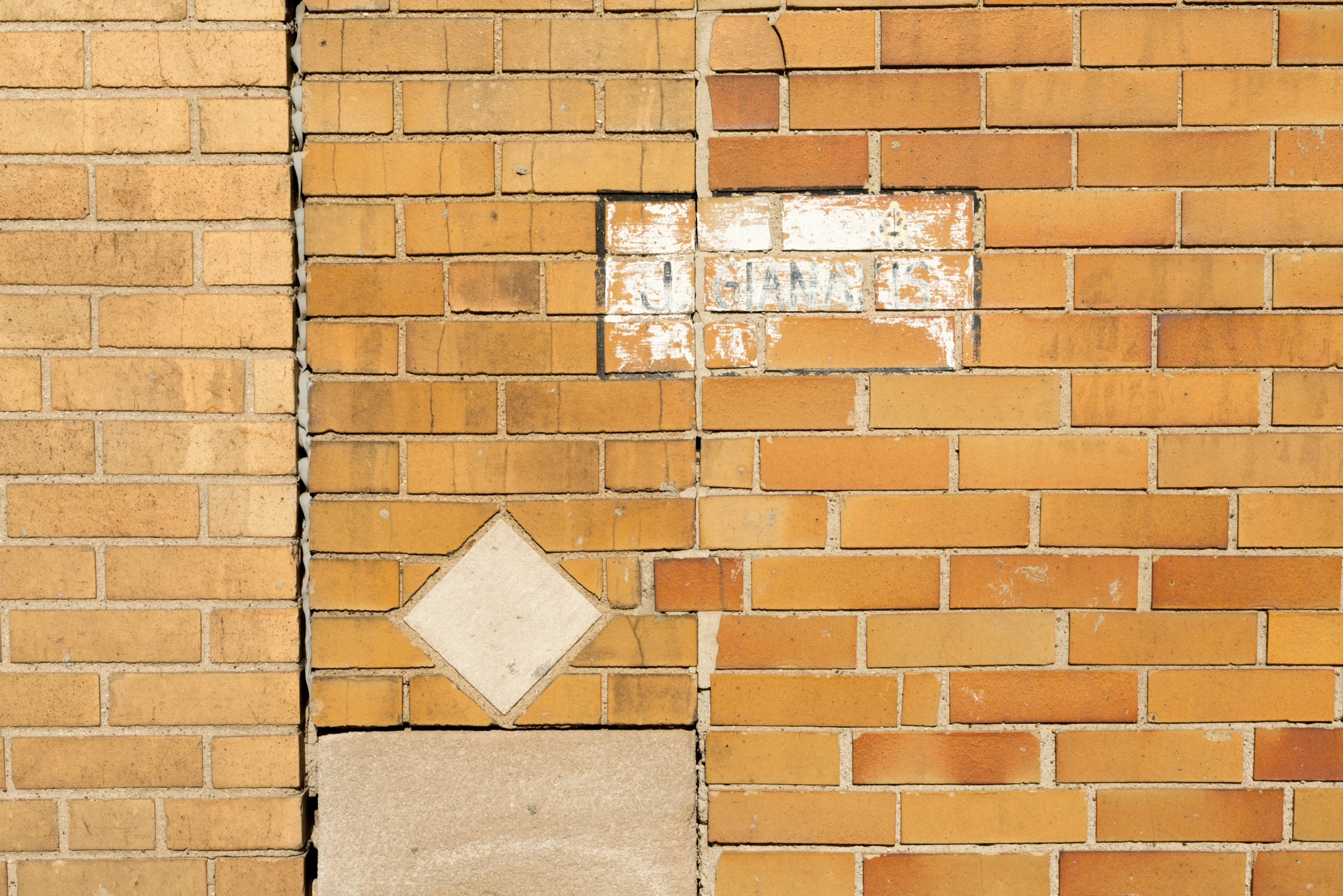 a small square sign on the side of a brick wall