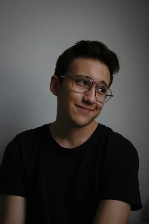 a man with glasses smiles in the dark