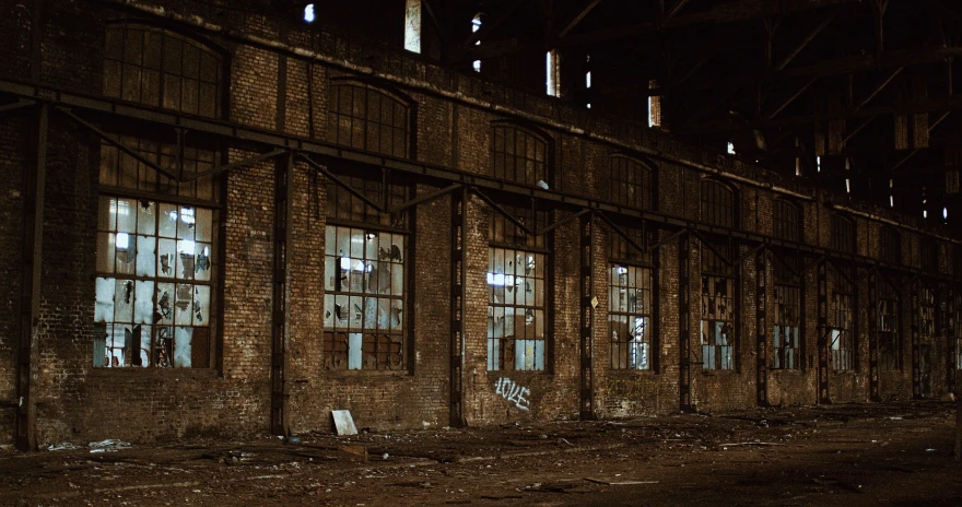 the windows of an abandoned warehouse building are empty