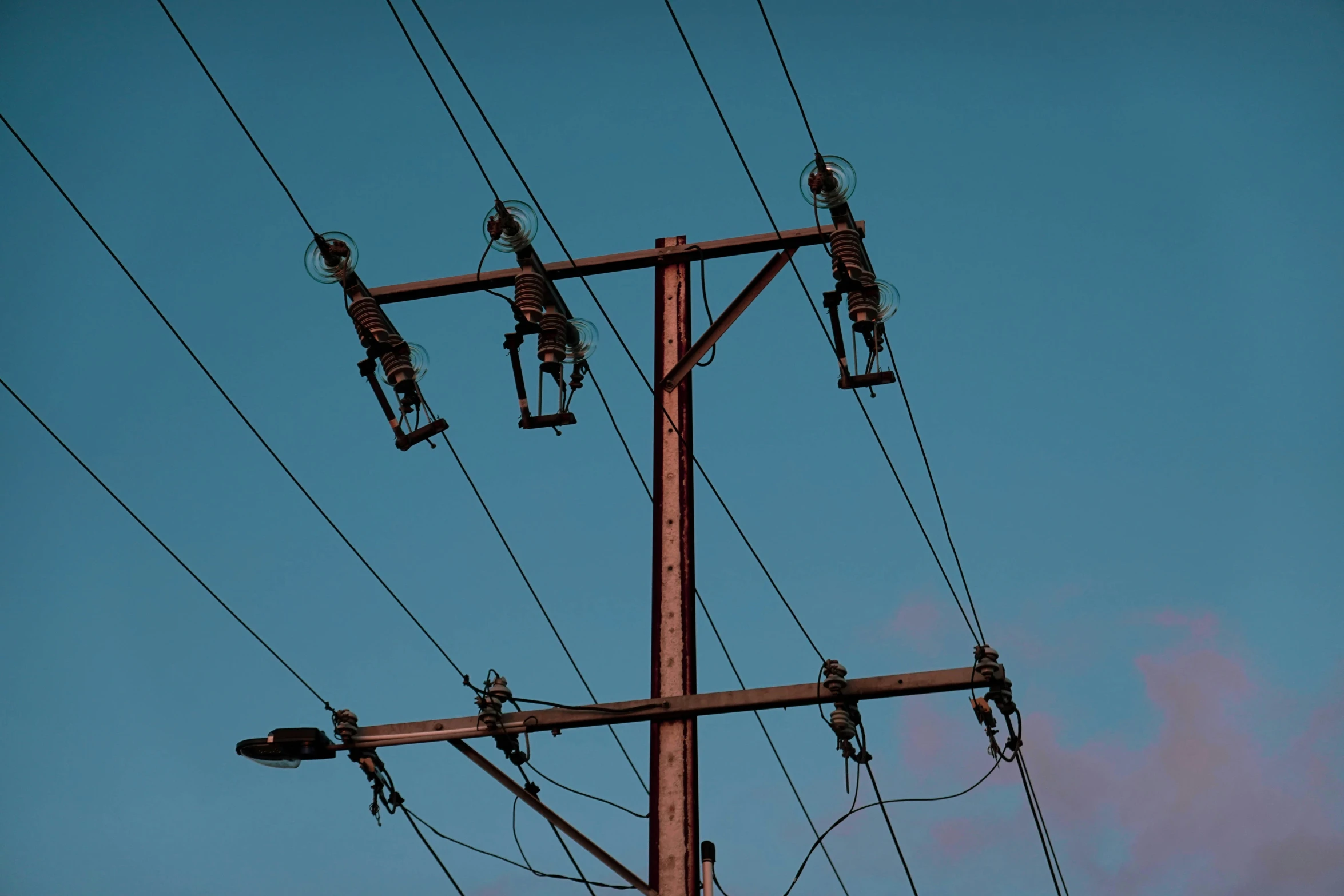 multiple power poles with the sky in the background