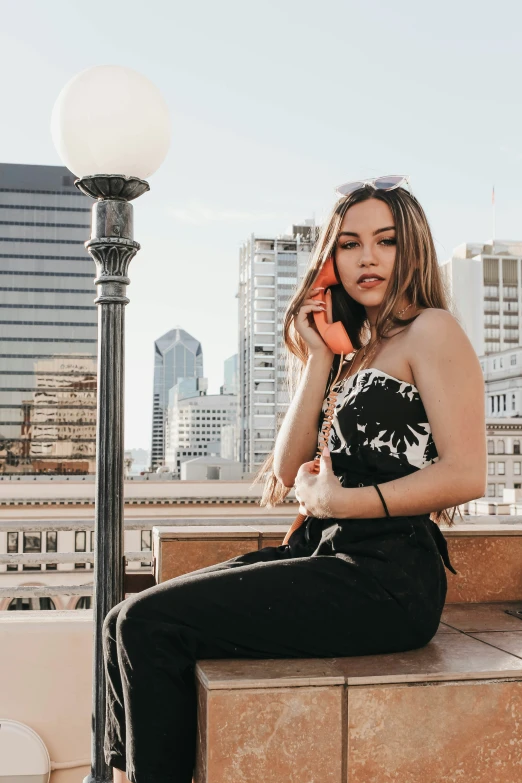 a woman sitting on top of a table on top of a cell phone