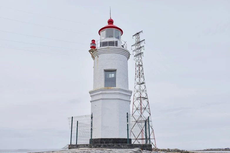 a red and white light house sitting on top of a hill