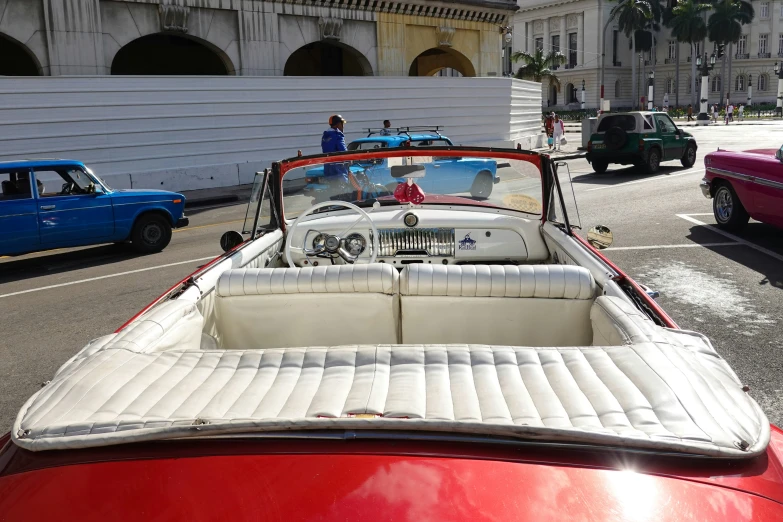 a classic convertible car sitting in front of an old building