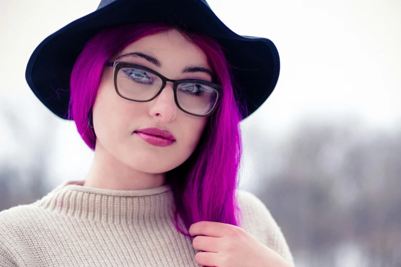 a young woman with purple hair and glasses on