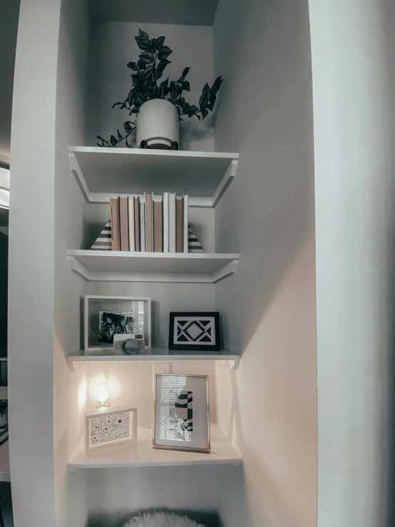 shelves with pictures, pictures and a white chair