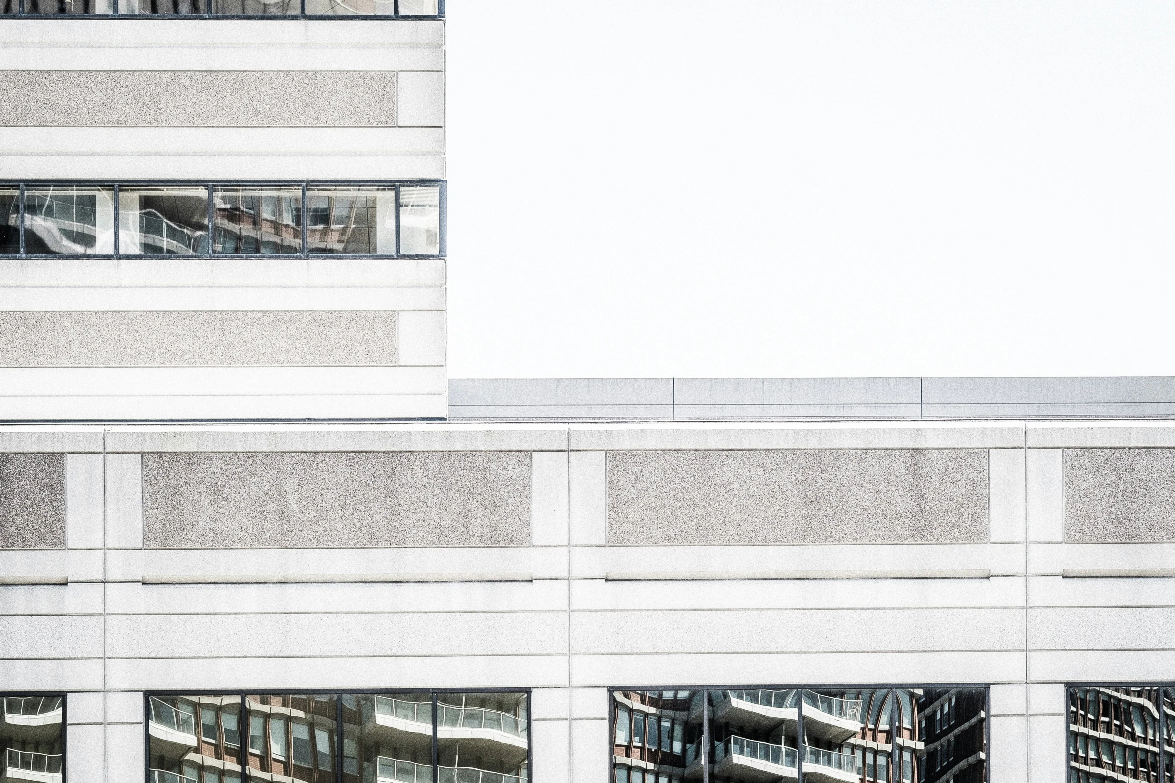 the reflection of two people in windows on a building