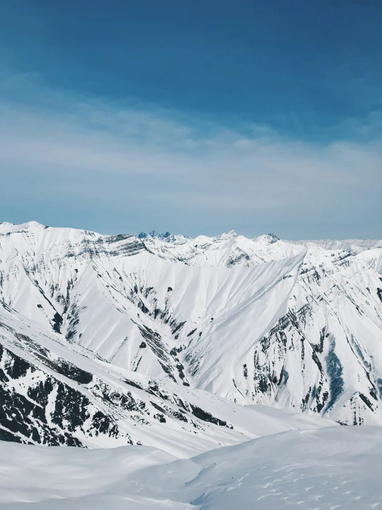 some mountains covered with snow and clouds in the daytime