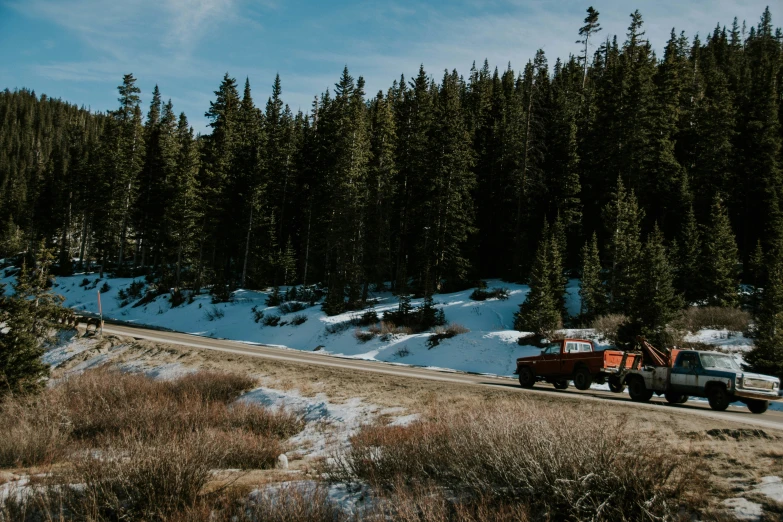 two trucks moving on a snowy mountain road