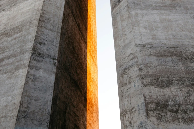 two tall concrete pillars in front of a sky