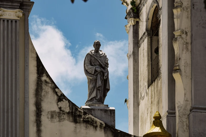 a statue standing next to a tall building