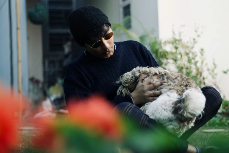 a man in sunglasses is holding a small animal