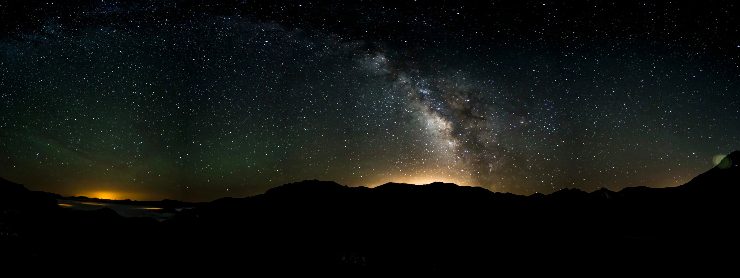 a view of some mountains under a starr filled sky