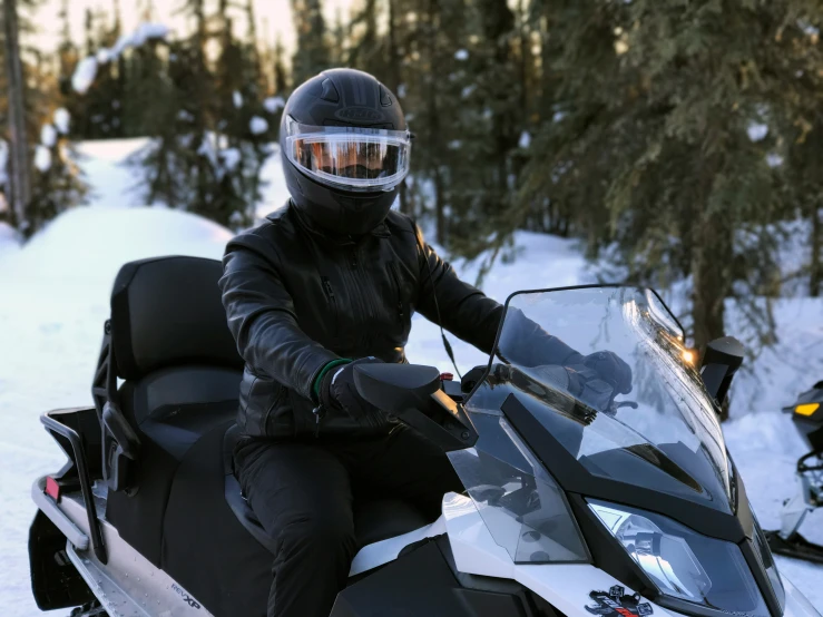 a person is sitting on a snowmobile wearing skis