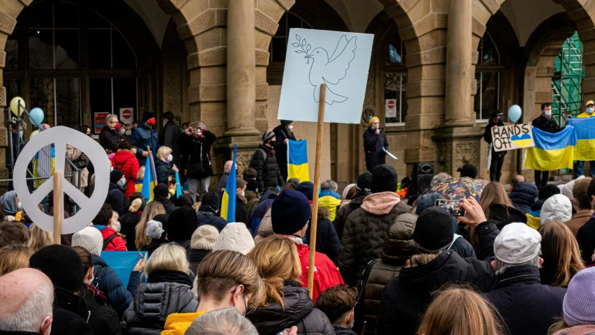 the crowd is protesting outside with banners on their heads