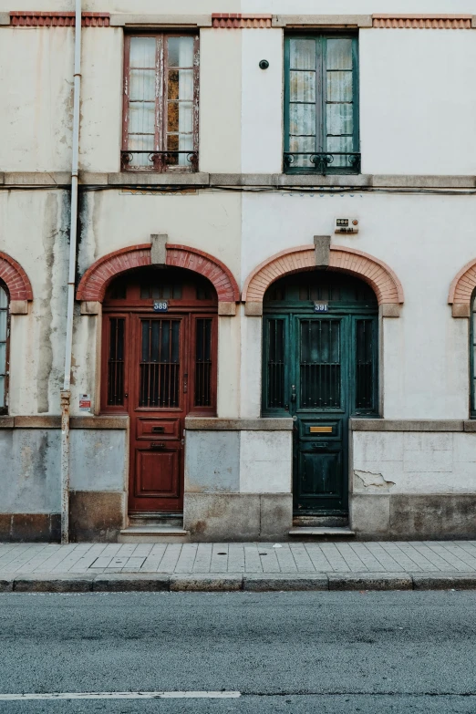 old style white building with three door and green trim