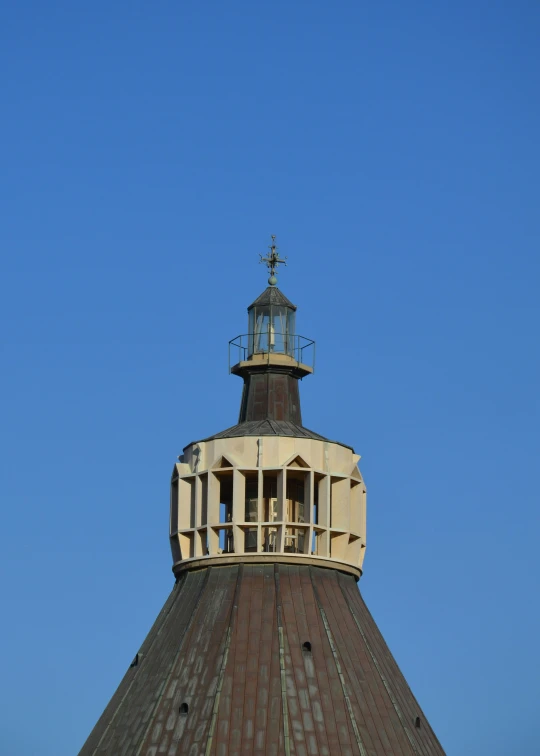 a clock tower with an unusual cross on top