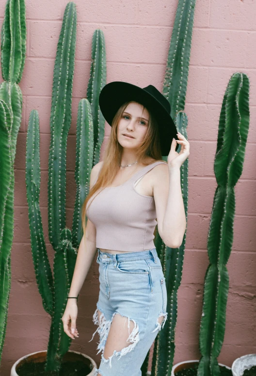 a  poses in front of a cactus