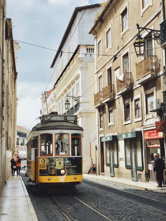 a trolley driving down the road next to buildings