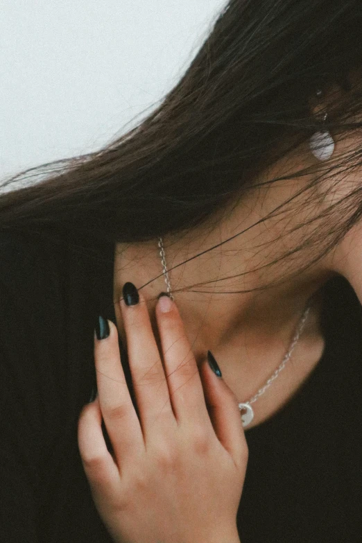 an image of a woman's finger with a black manicure