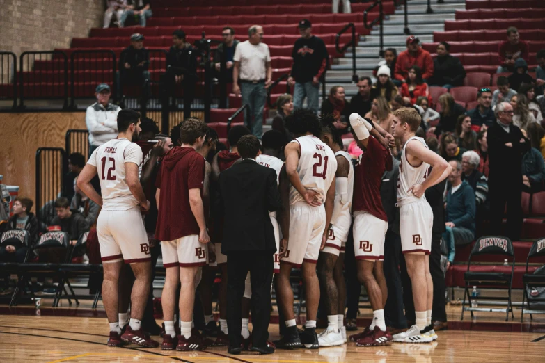 the men's basketball team is huddled together during a game