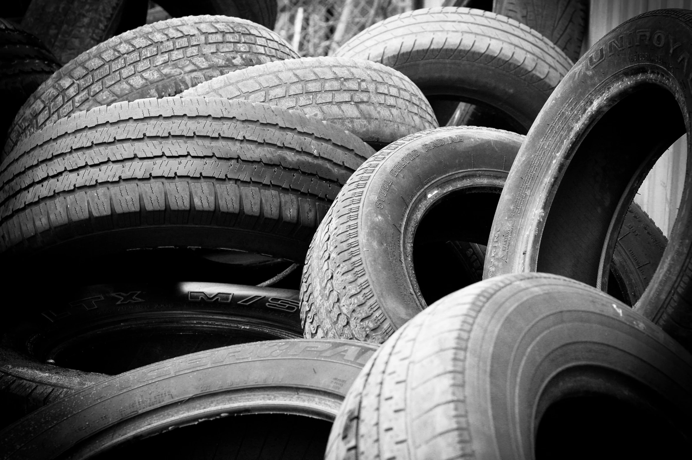 several tires piled up together with one standing on top of it