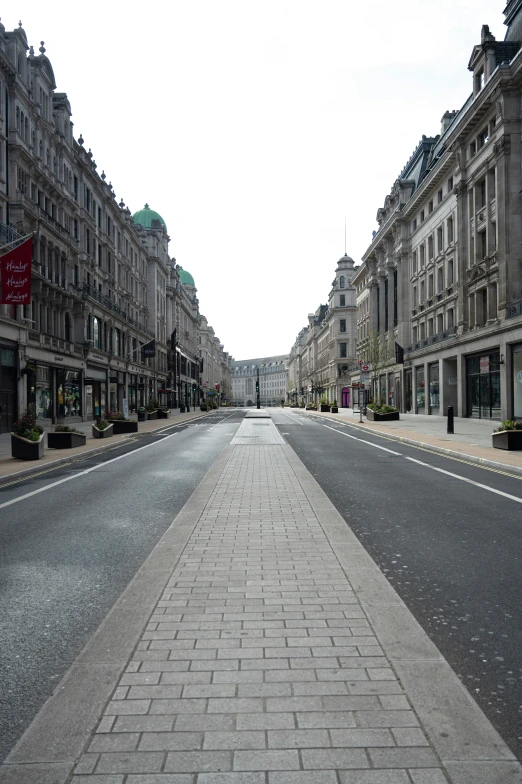 a quiet, empty street leading to some older buildings