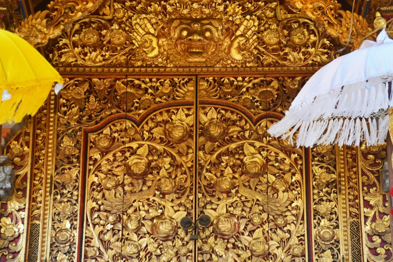 an ornate gold and white door with an open umbrella