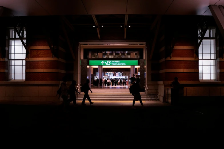 people entering a building, at night with lights on