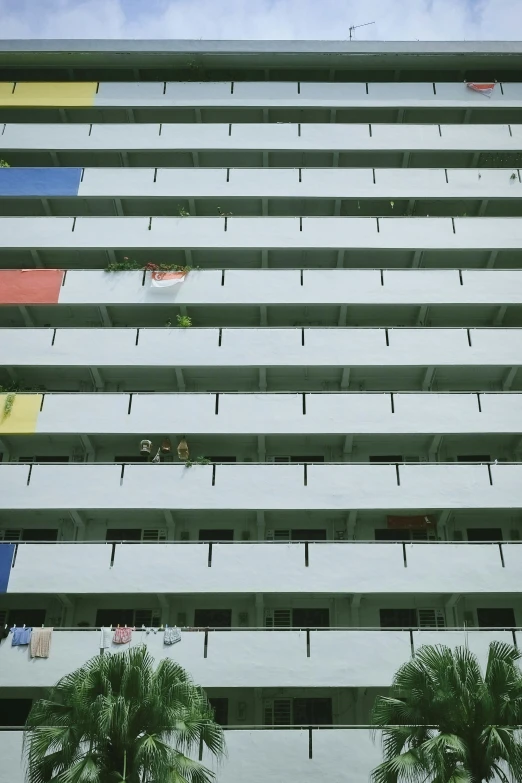 a tall white building that has windows and balconies