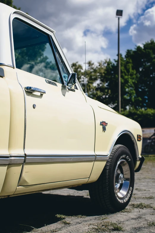 an old yellow pickup truck parked in a field