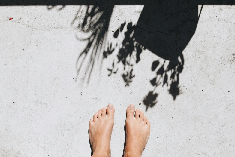 a person's feet against the concrete of a wall