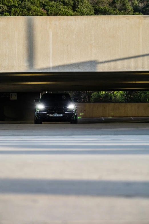 the car is parked under a bridge by the street