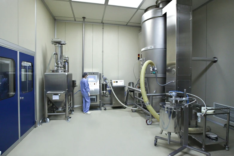 a man standing inside of a large factory with several machines