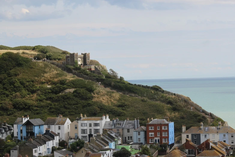 several houses are on the side of a hill near the ocean