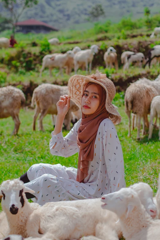 a woman wearing a brown and white hat with some sheep