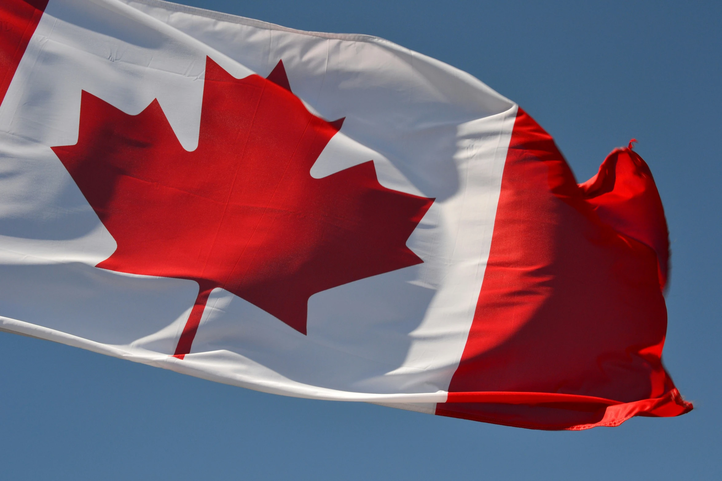 an american and canadian flag flying in the sky