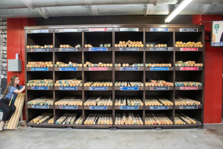 a woman sitting on a bench next to a large display of pastries