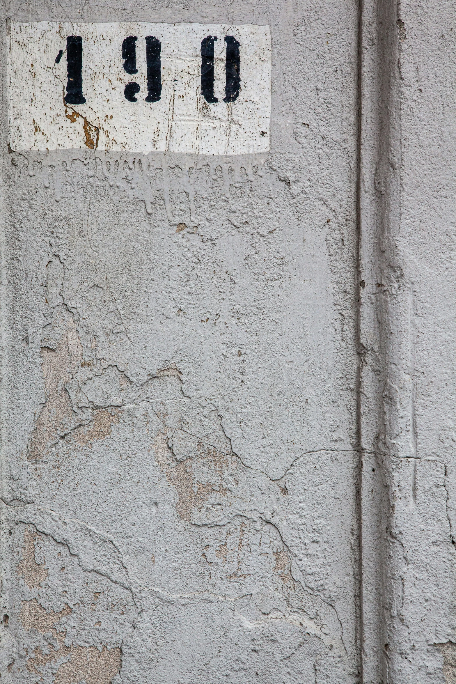 a yellow fire hydrant in front of a cement wall